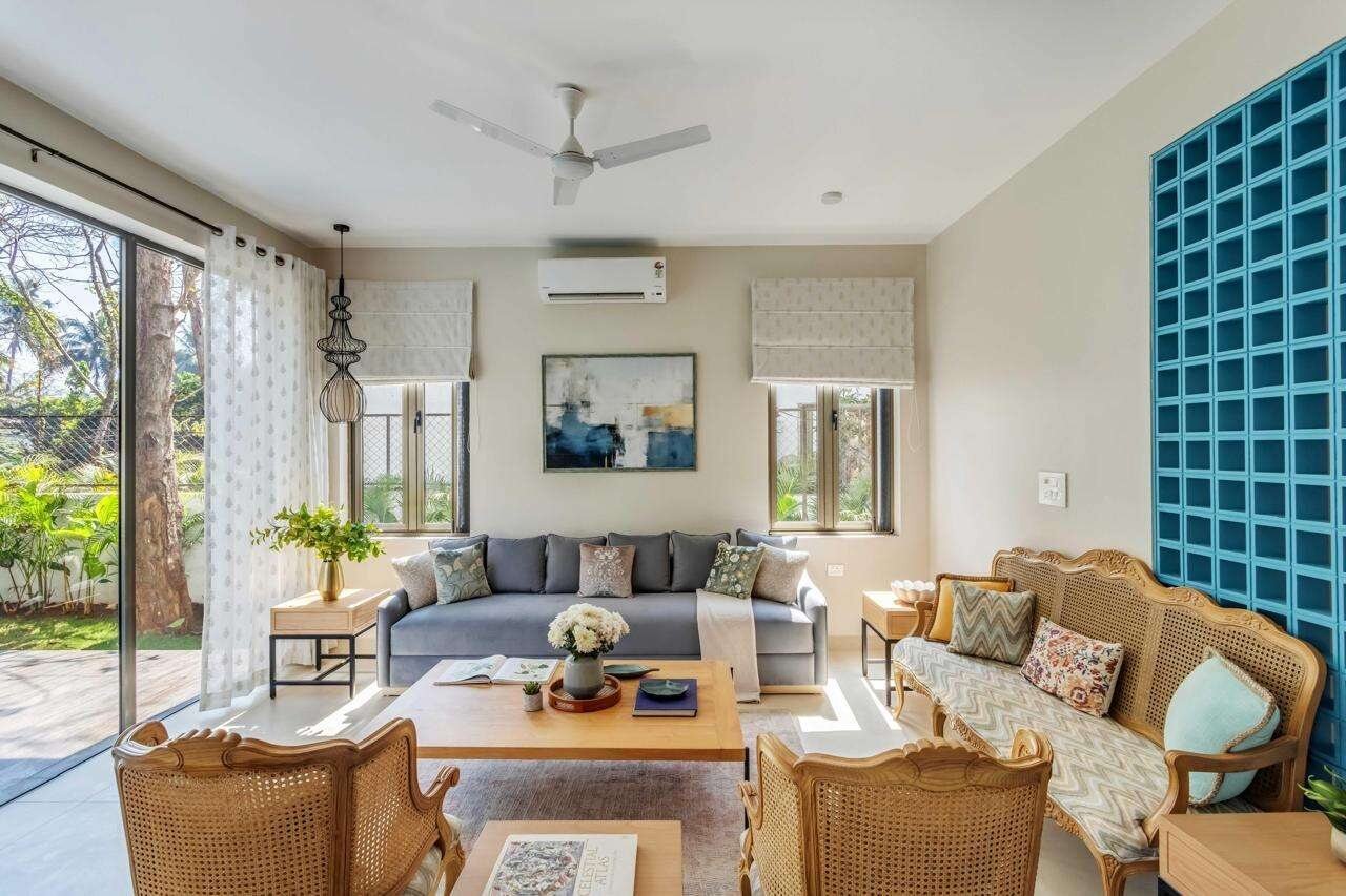 Villa living room with rattan armchairs and blue glass-block feature wall