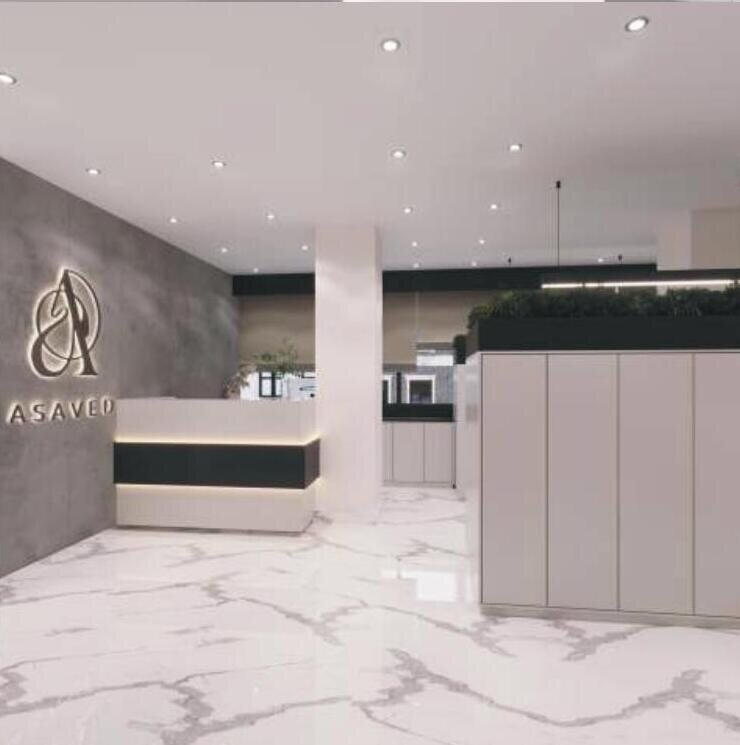 Reception desk with backlit signage and marble flooring